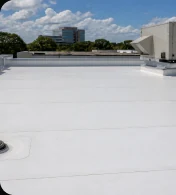 White commercial roof membrane with seams and rooftop equipment.