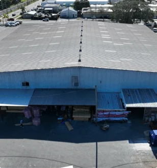 Aerial view of a warehouse with a broad low-slope roof.