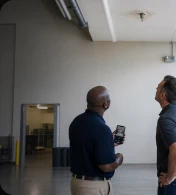 Two people examining the ceiling inside a commercial building.