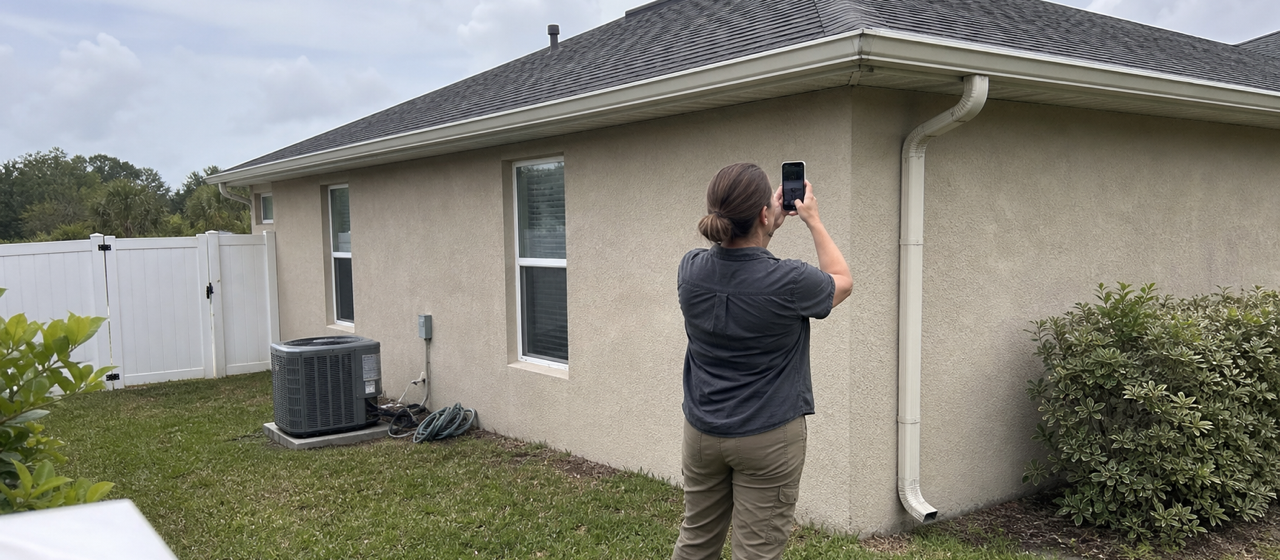 A person looking at a house roof from ground level.