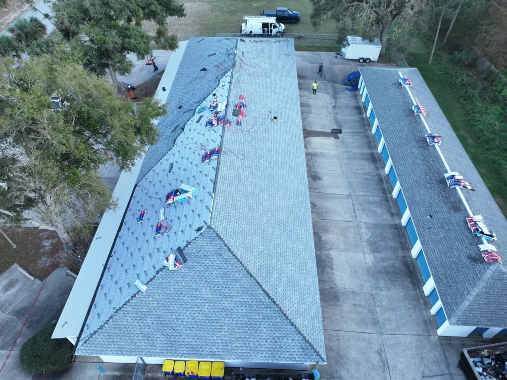 Aerial view of shingle installation on two Edgewater storage buildings