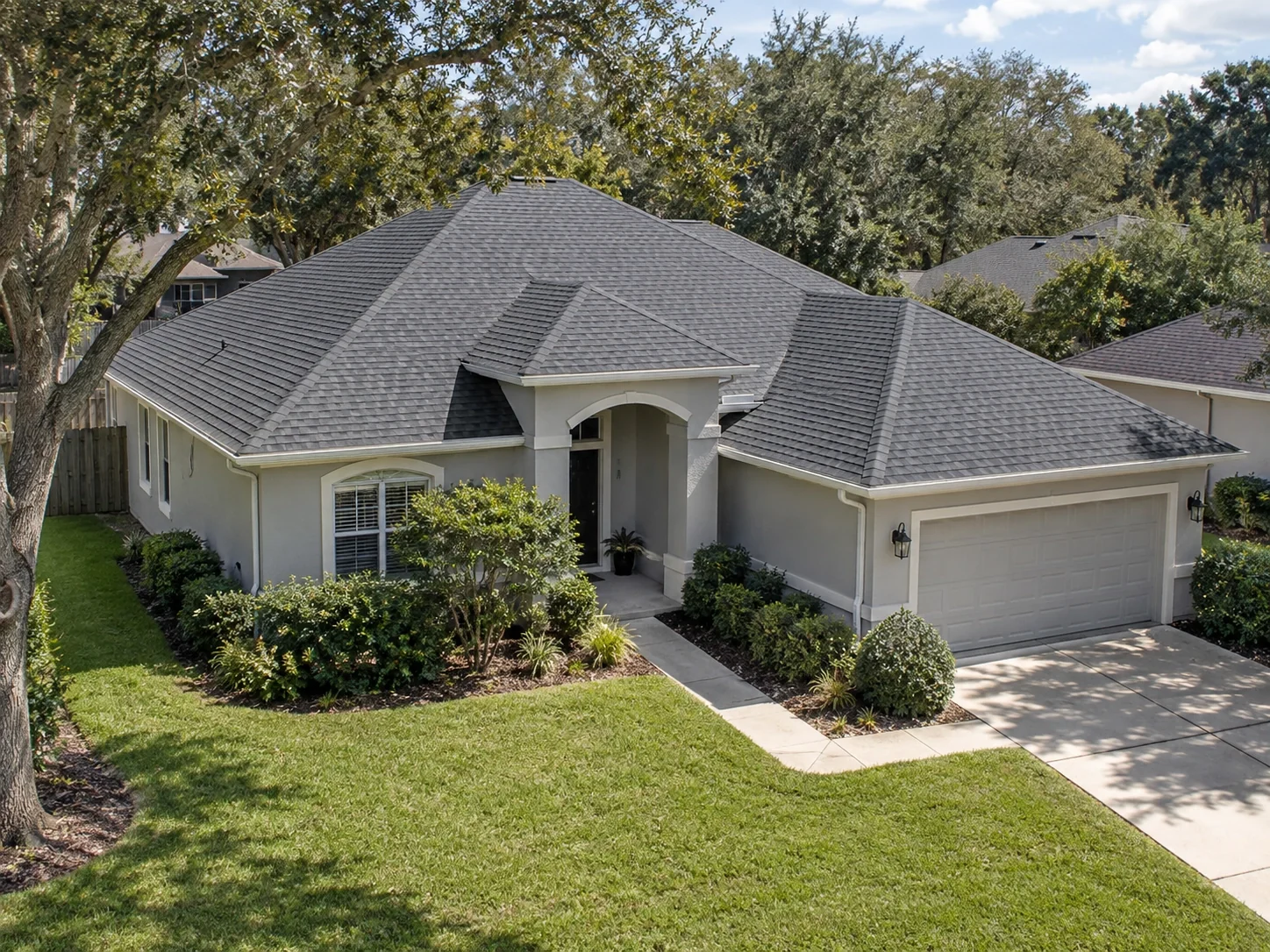 Residential house with a charcoal shingle hip-and-valley roof.