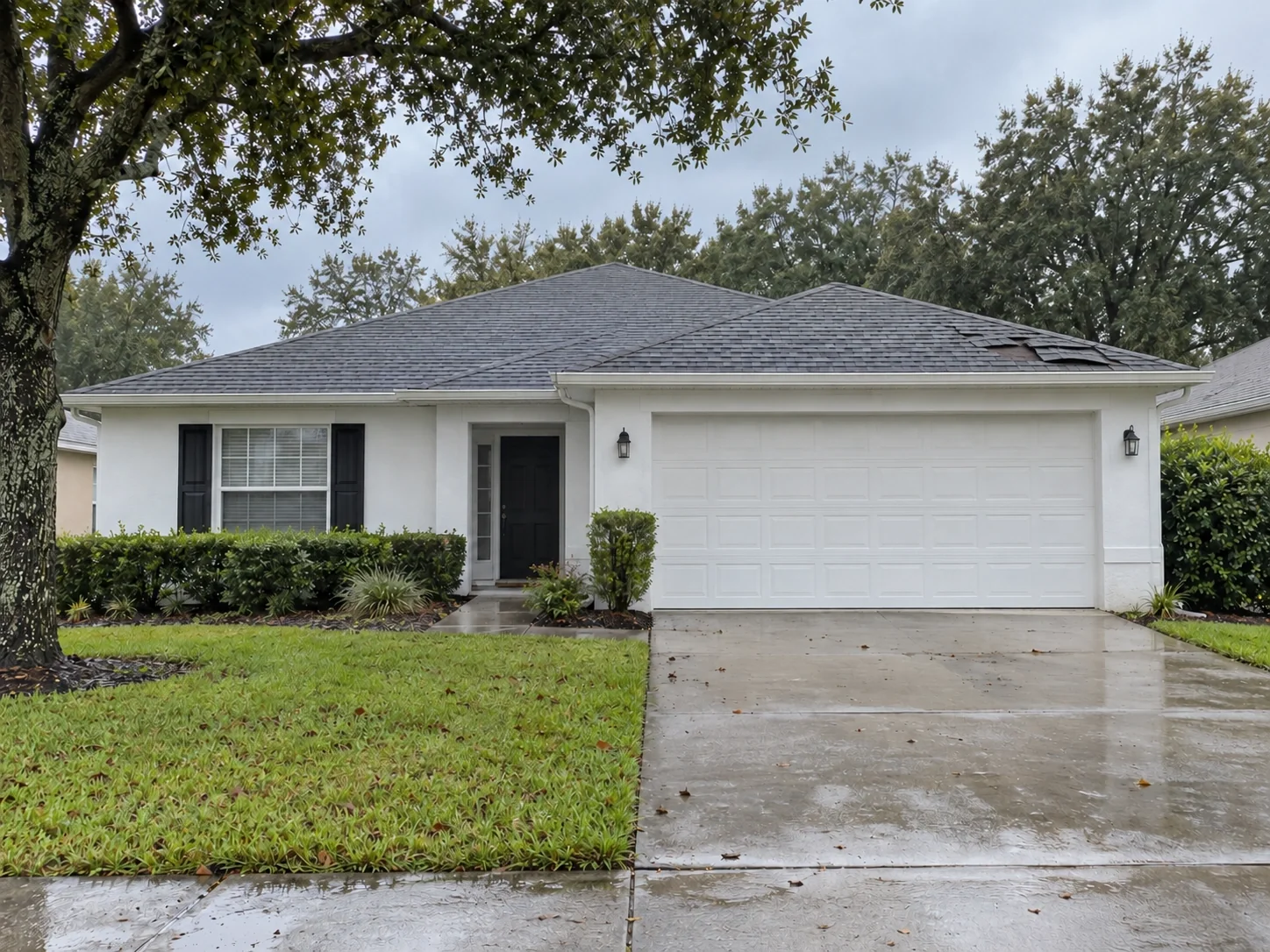 Home with a small area of lifted roof shingles after wind and rain.
