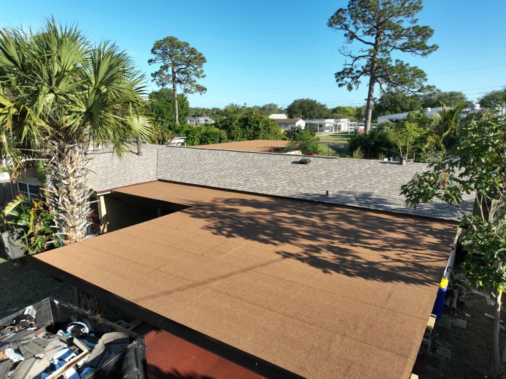 Finished modified-bitumen flat roof sections beside the new shingles