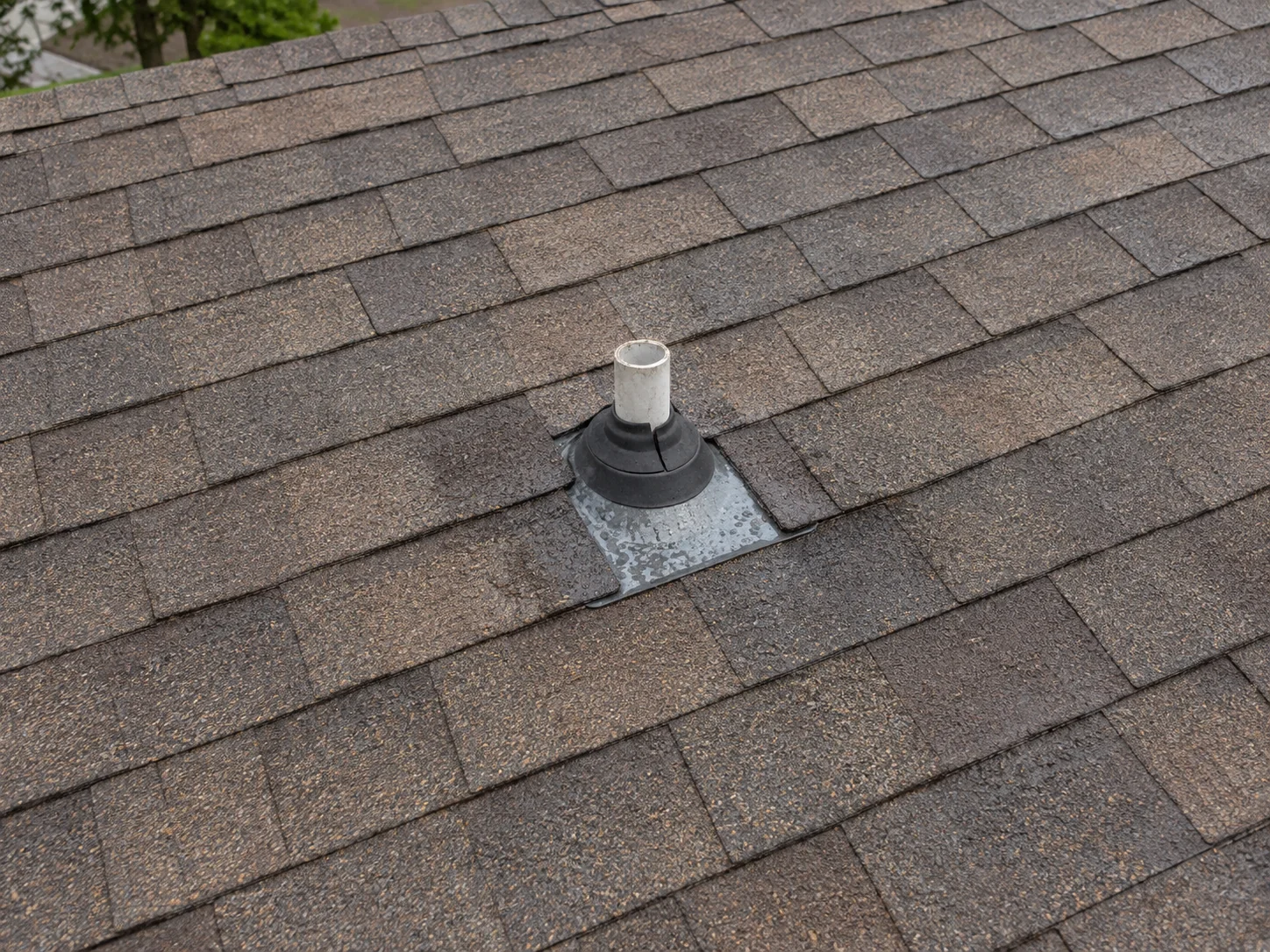 Damp flashing and a split rubber boot around a roof vent pipe.