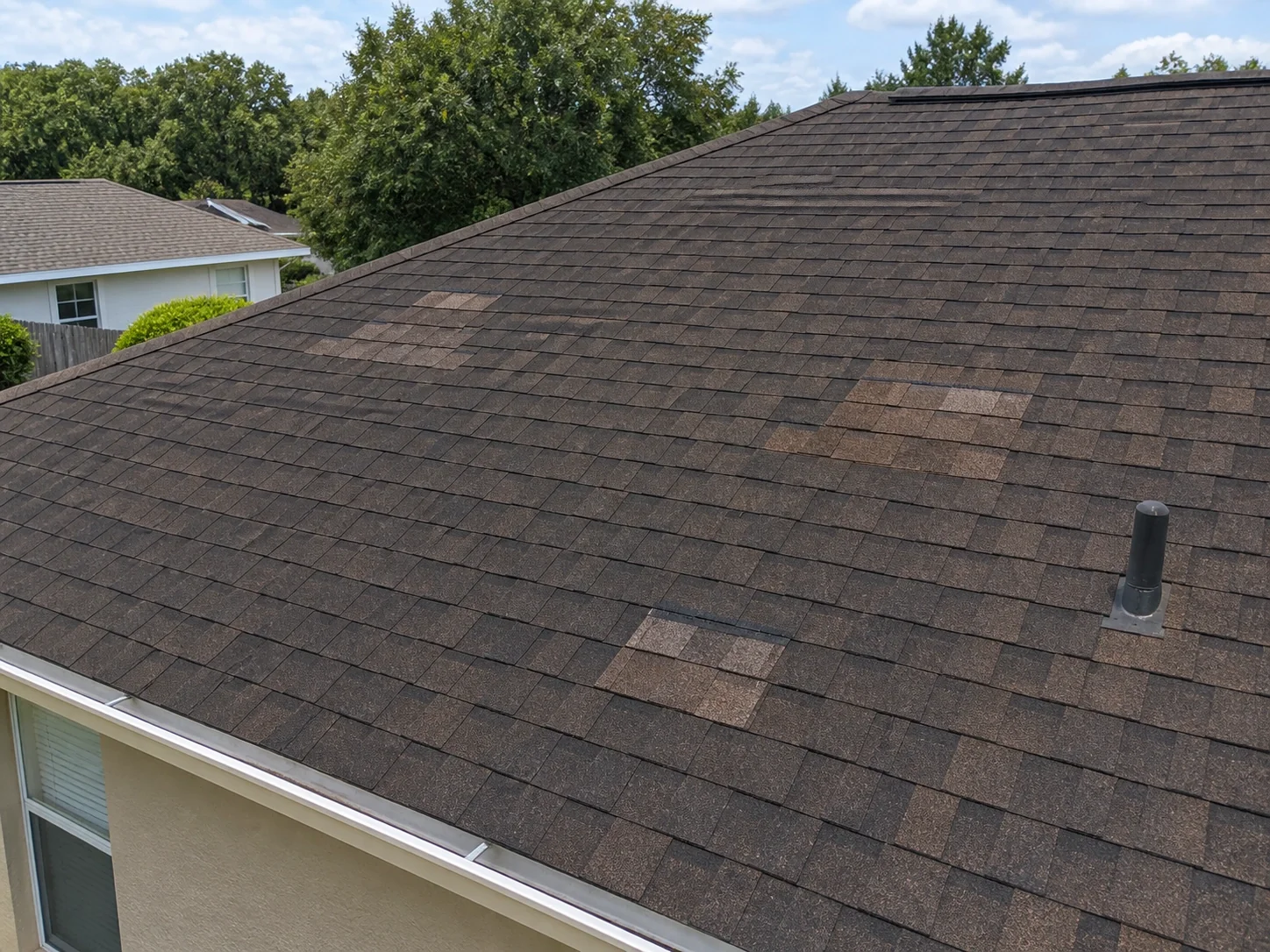 Several older repair patches across an asphalt-shingle roof.