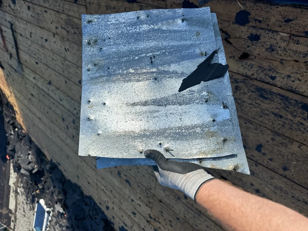 Removed sheet-metal patch held above the Winter Park roof deck