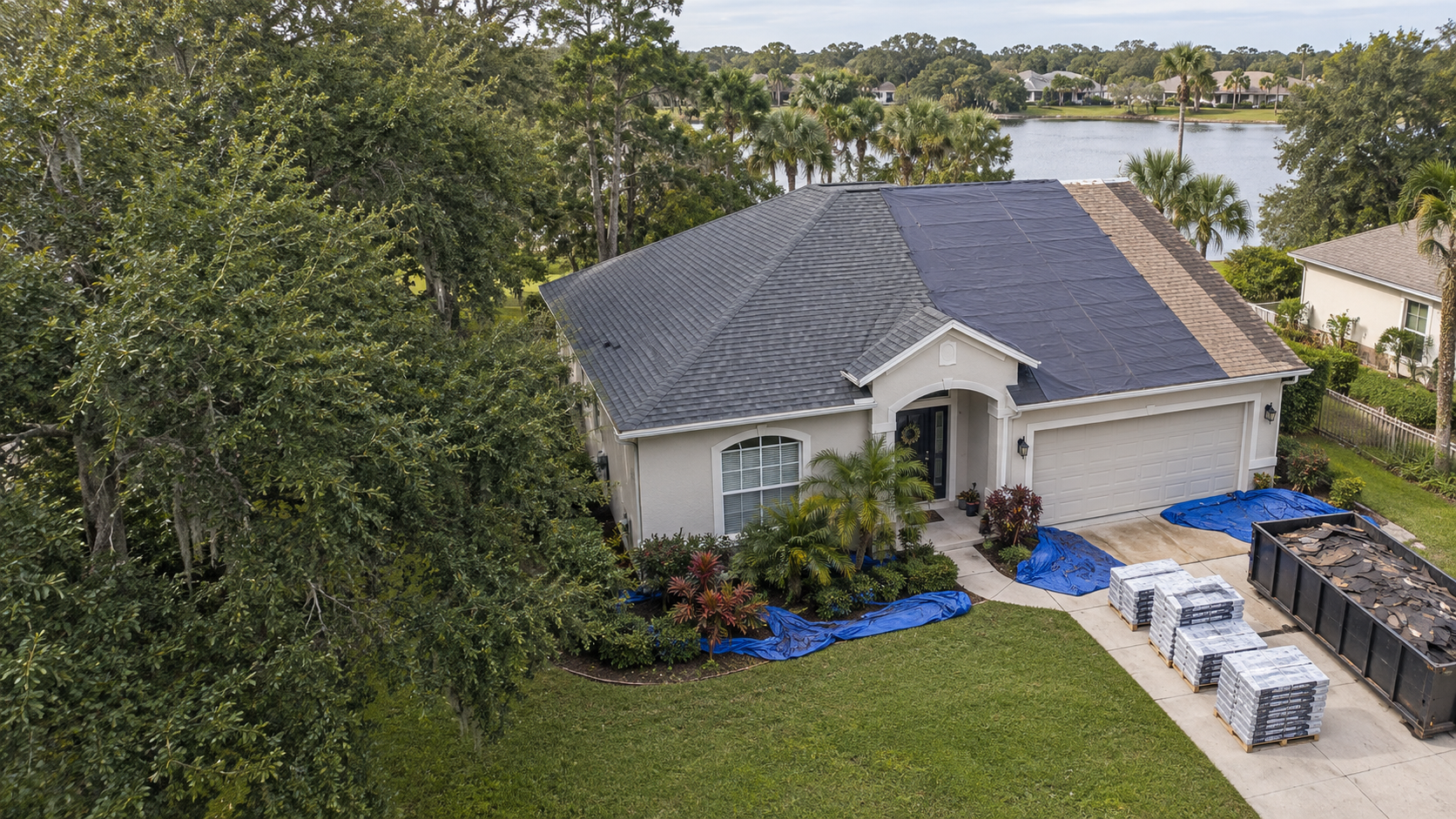 Aerial view of a house with a shingle roof and a swimming pool.